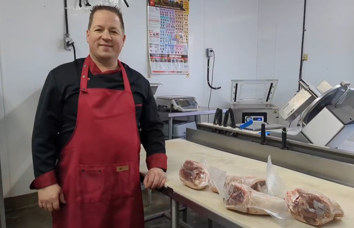 Benoit Bonneau, propriétaire, devant un comptoir de viande.