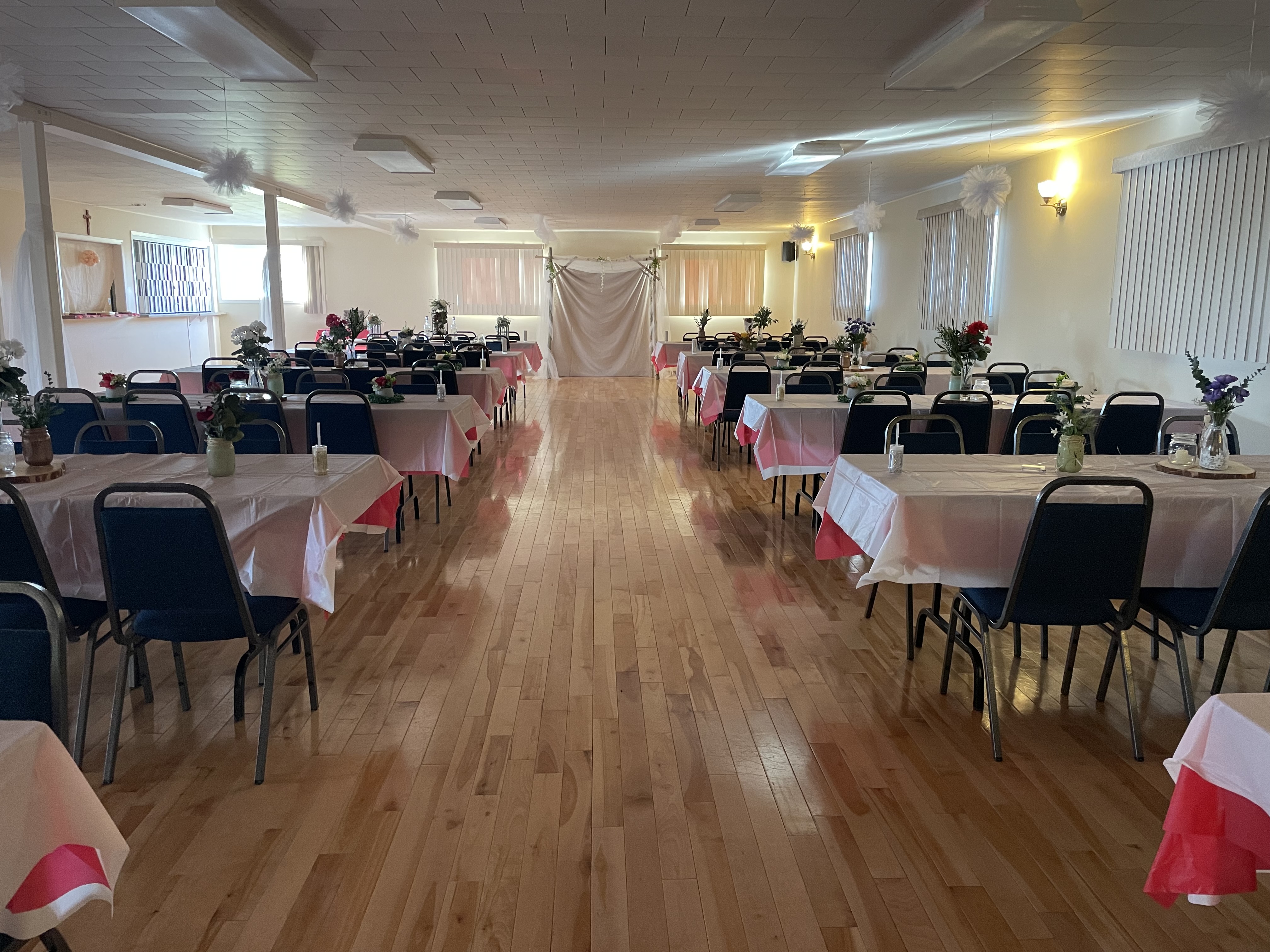 La salle communautaire de Lefaivre présentant 12 tables rectangulaires bien décorées.
