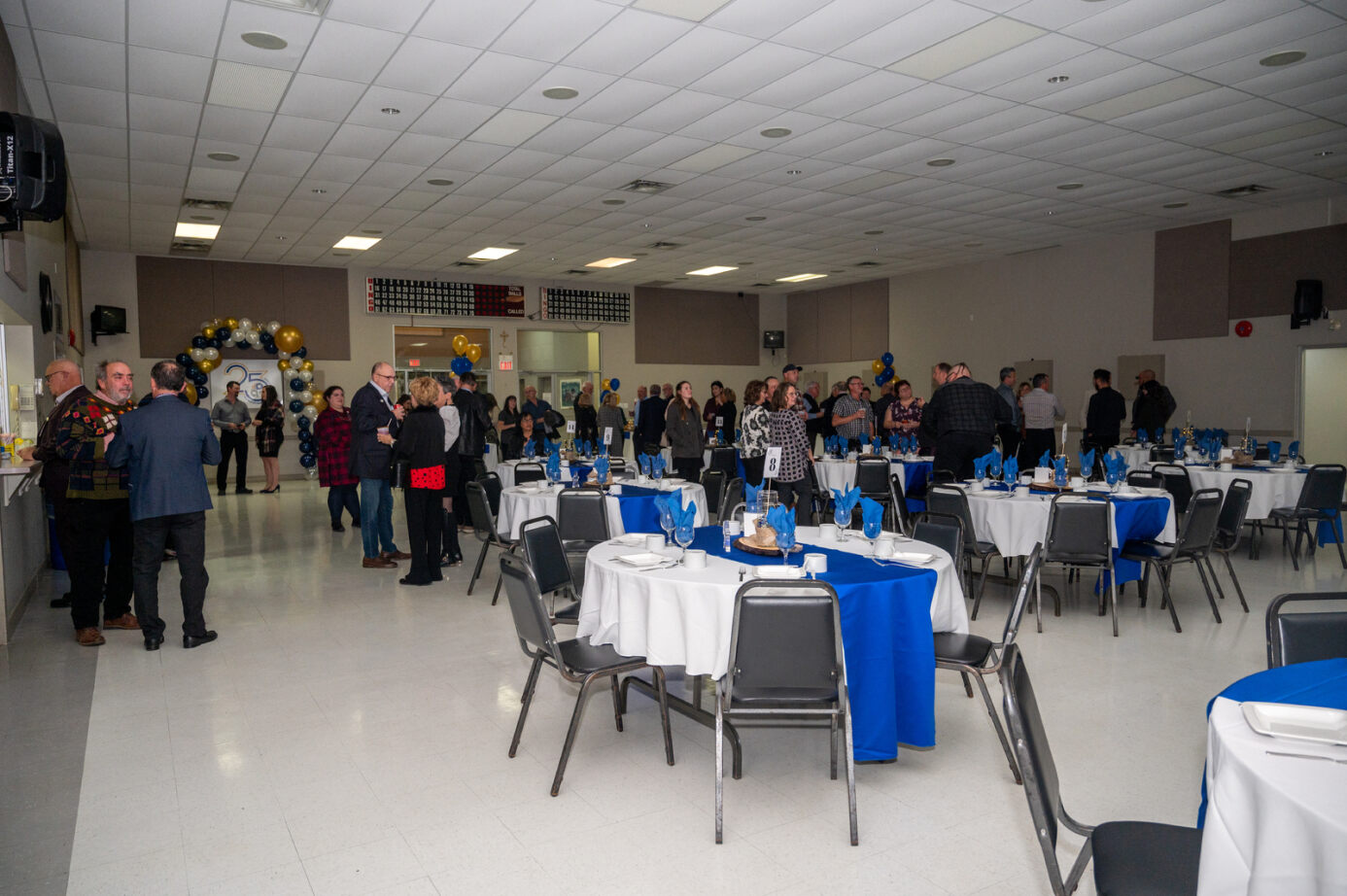 Circular tables decorated with people standing in the back