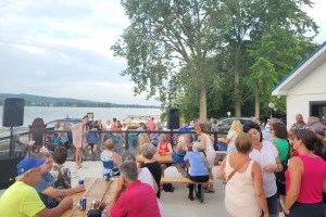 Une chanteuse avec une foule autour d'elle sur la terrasse