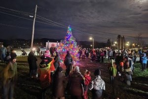 Groupe de gens autour de l'arbre de noel extérieur