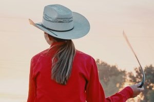 Fille avec un lasseau et un chapeau de dos