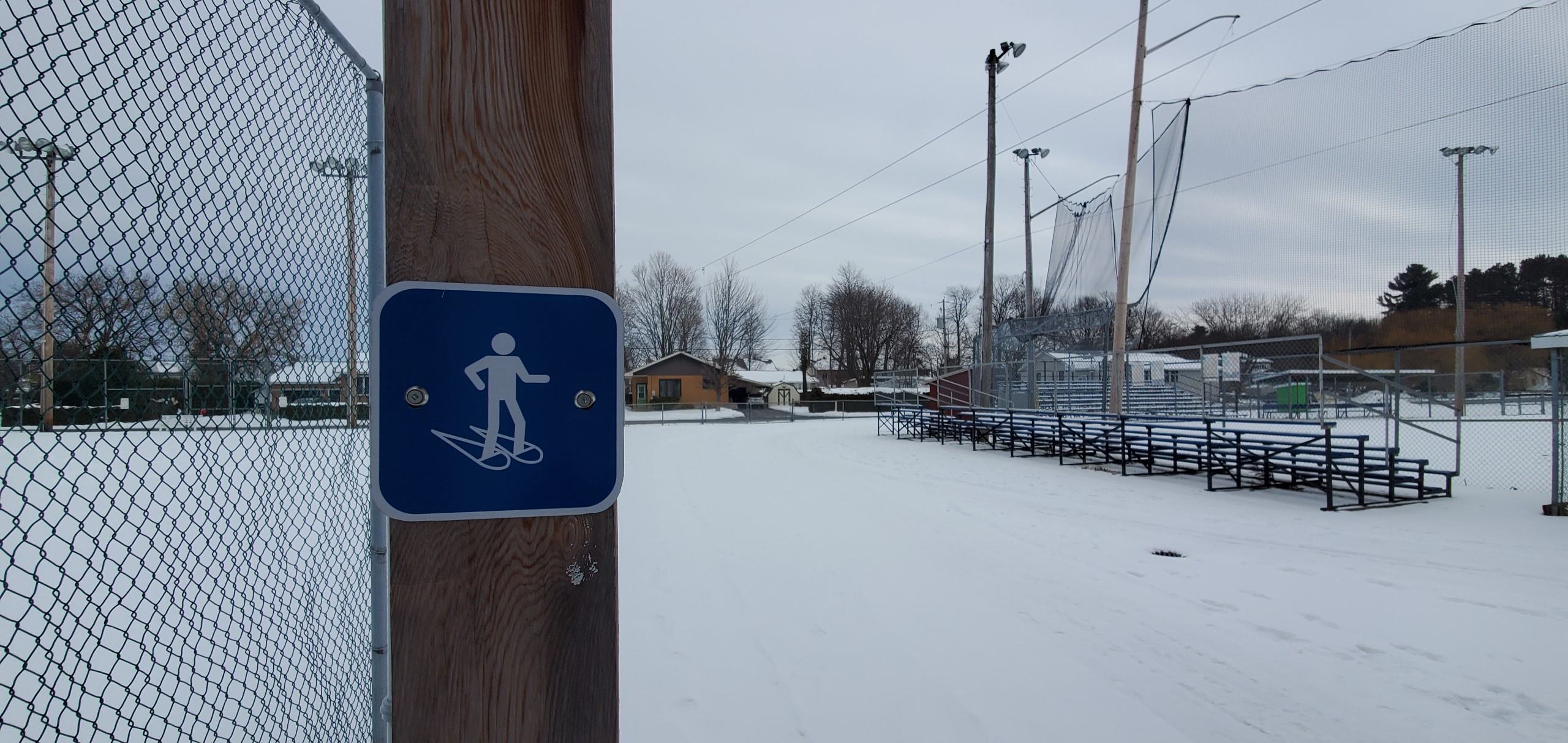 Snowshoeing sign on fence at a park
