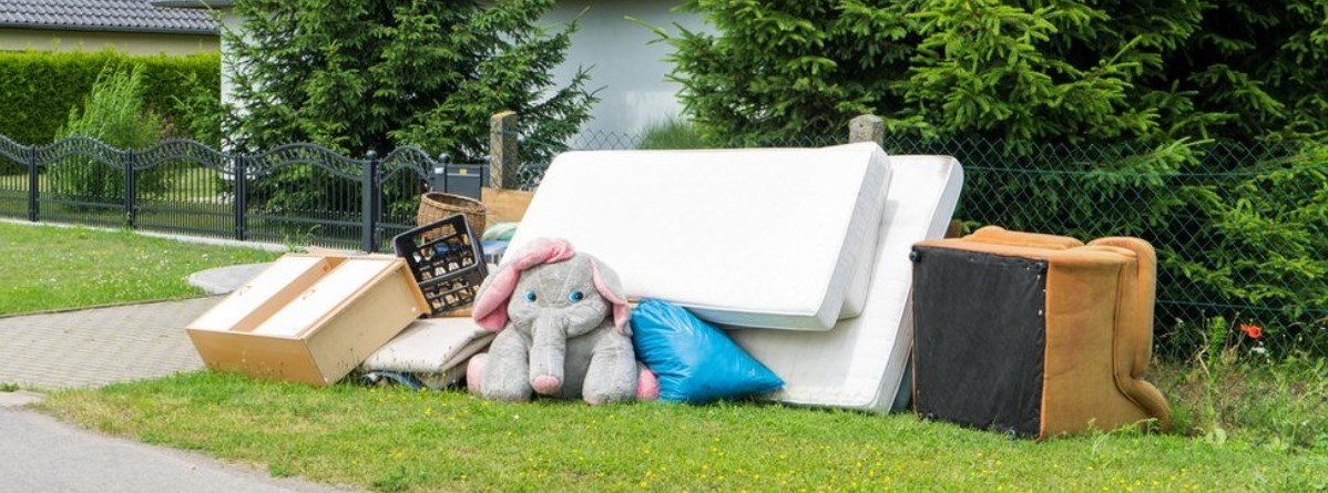 Mattresses, a couch, and various other large items at the curb for collection