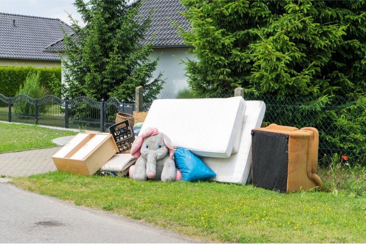 Mattresses, a couch, and various other large items at the curb for collection