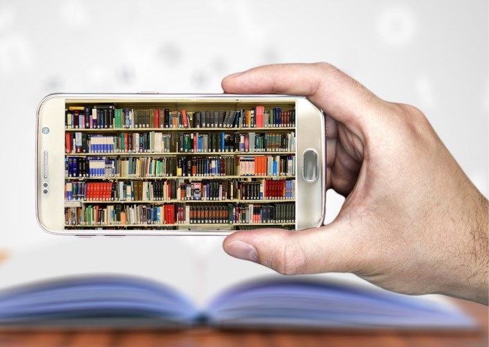 Téléphone intelligent avec photo de livres sur une étagère