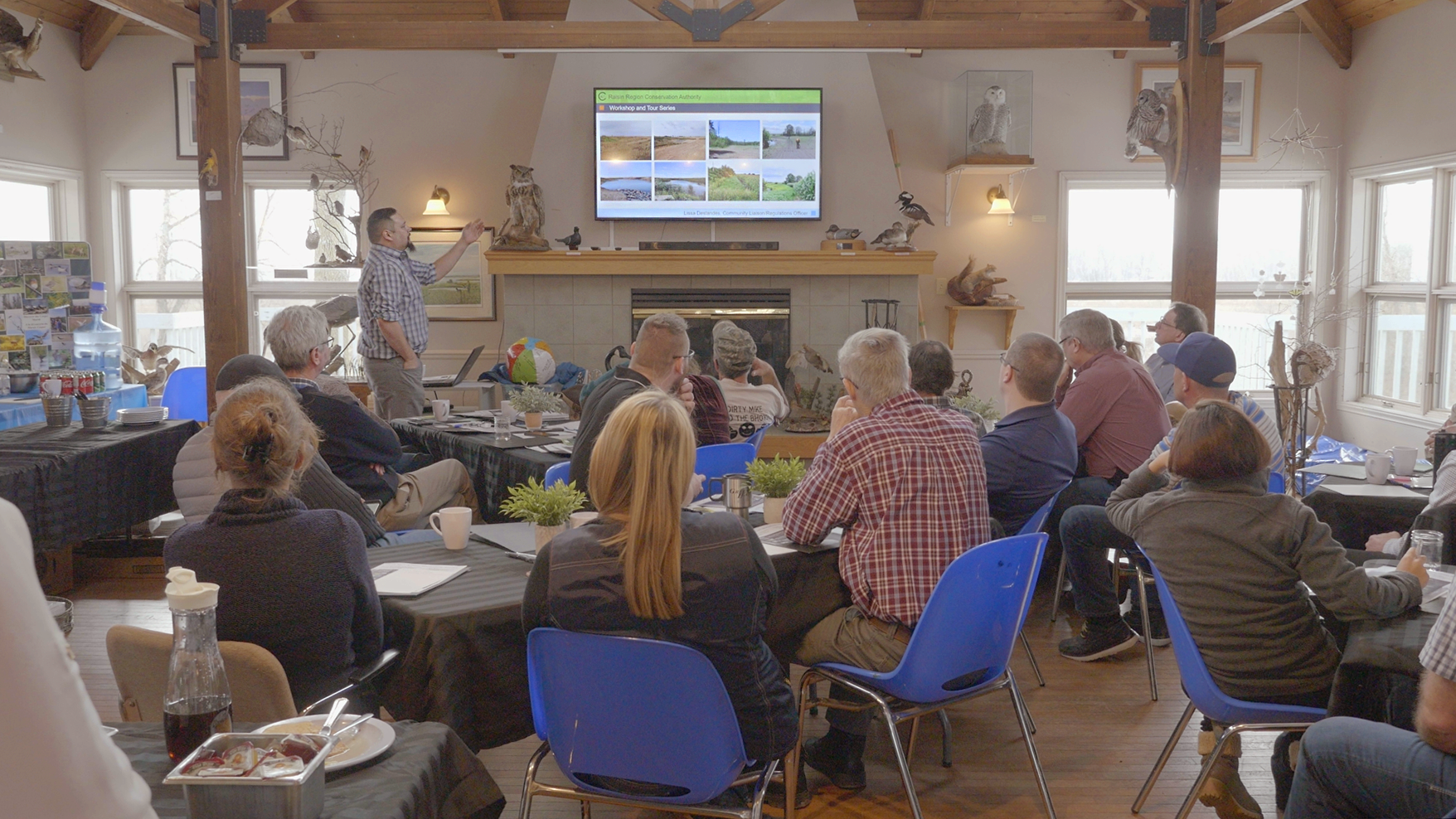 Community members watching a presentation in a rustic restaurant