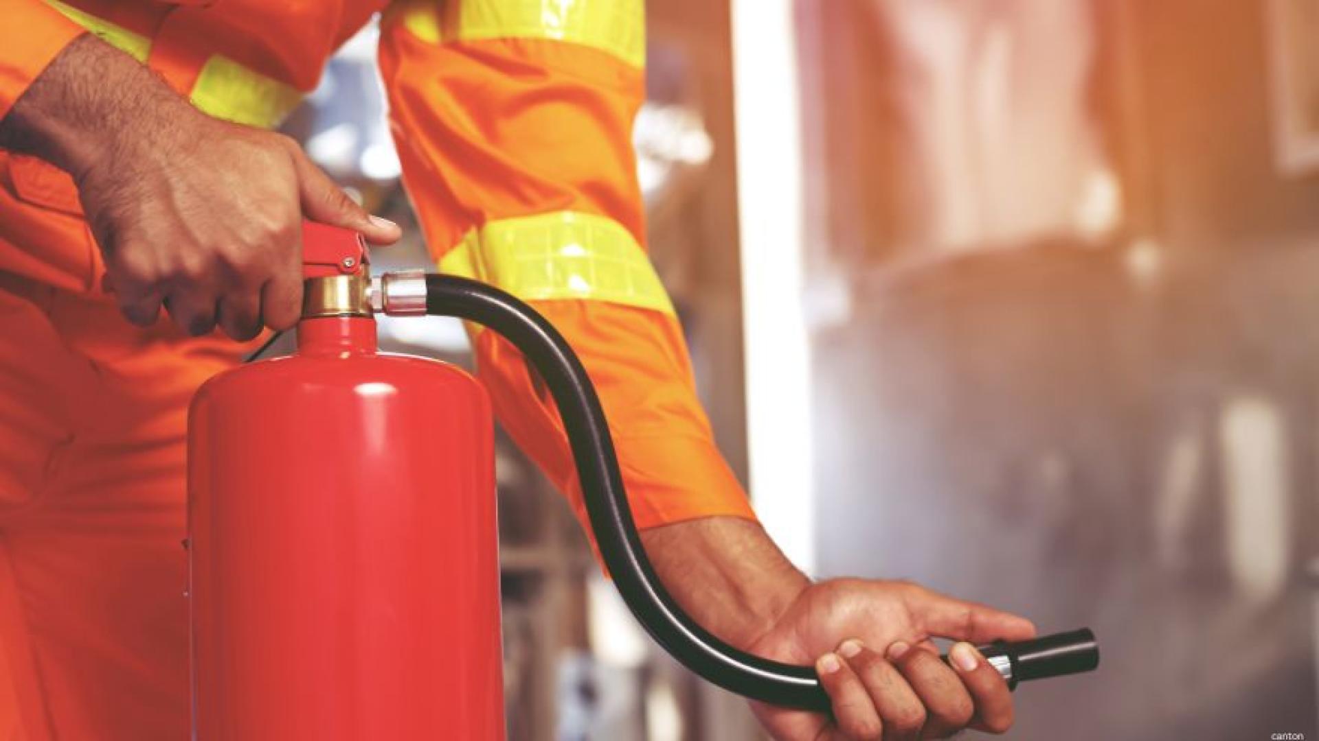 Firefighter inspecting a fire extinguisher