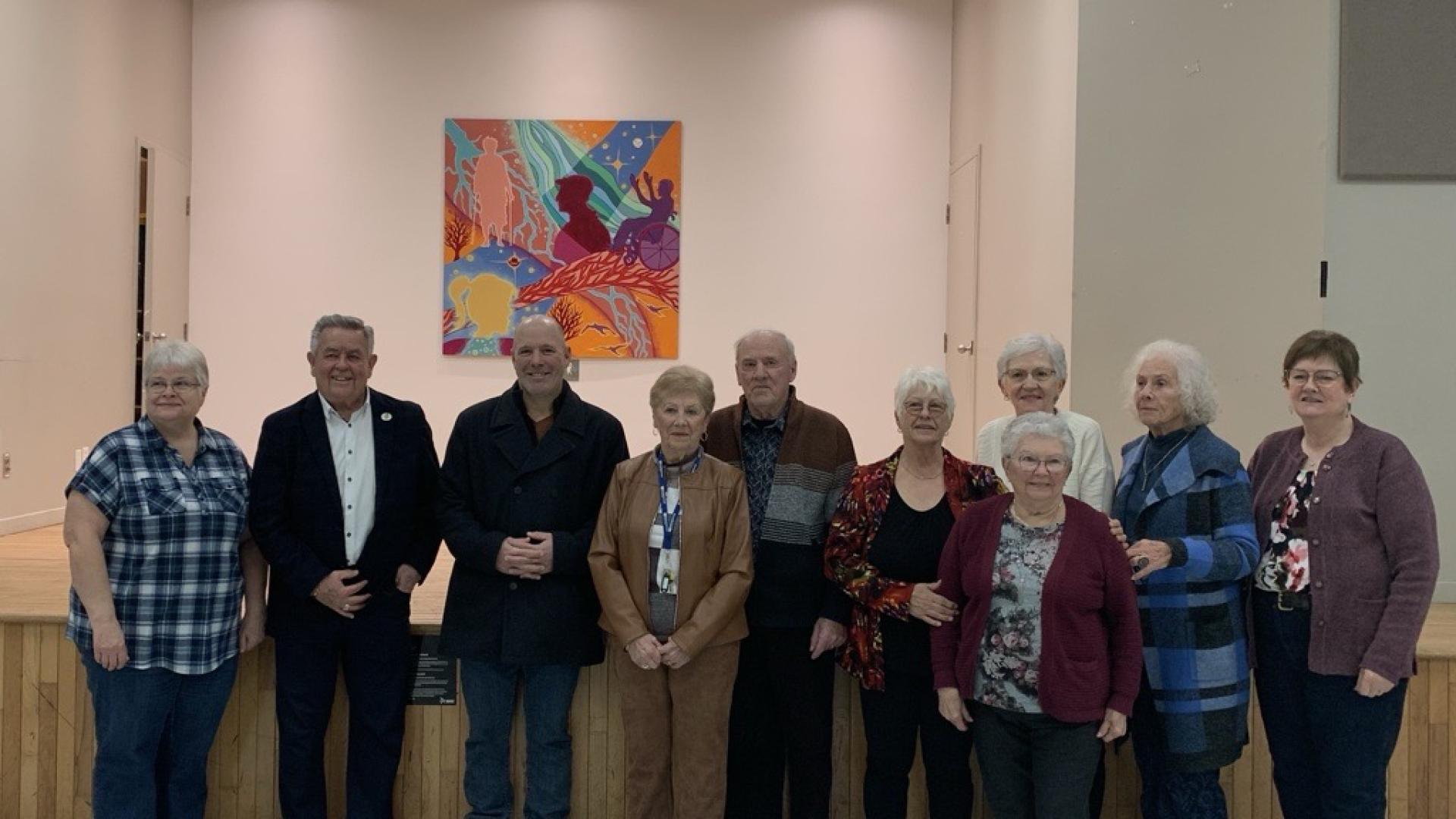 The council and participants standing in front a collective artwork
