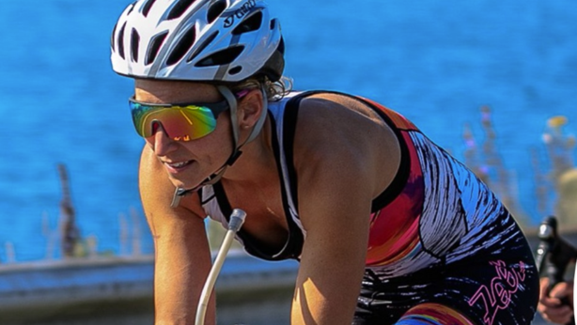 A woman on a bicycle with a river behind