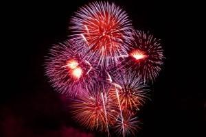 Feu d'artifice éclatant aux couleurs rouge et violet sur fond noir.